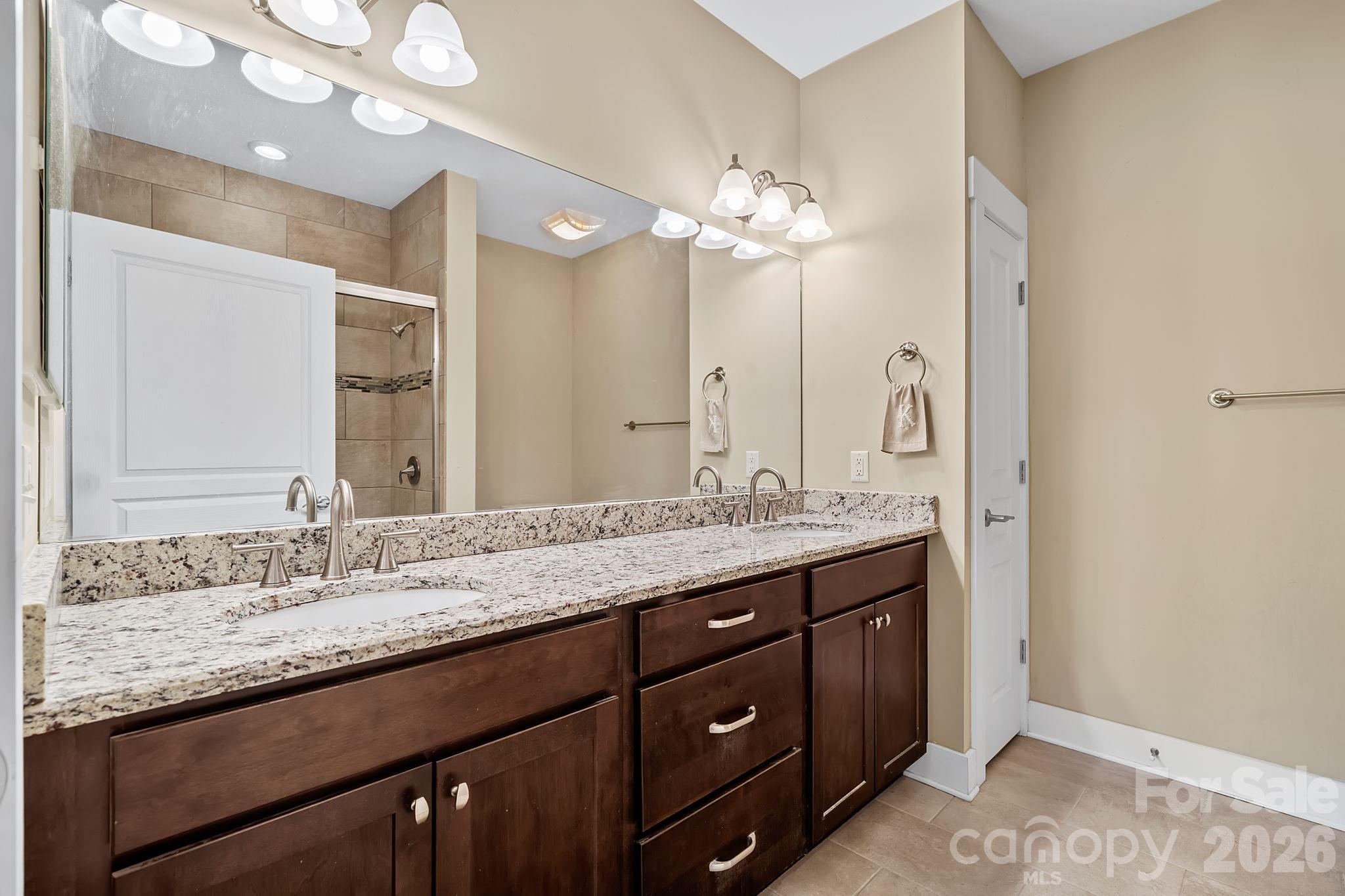 9 Brookstone Place Candler, NC 28715 - Photo 15 of 36 a bathroom with a granite countertop double vanity and a mirror
