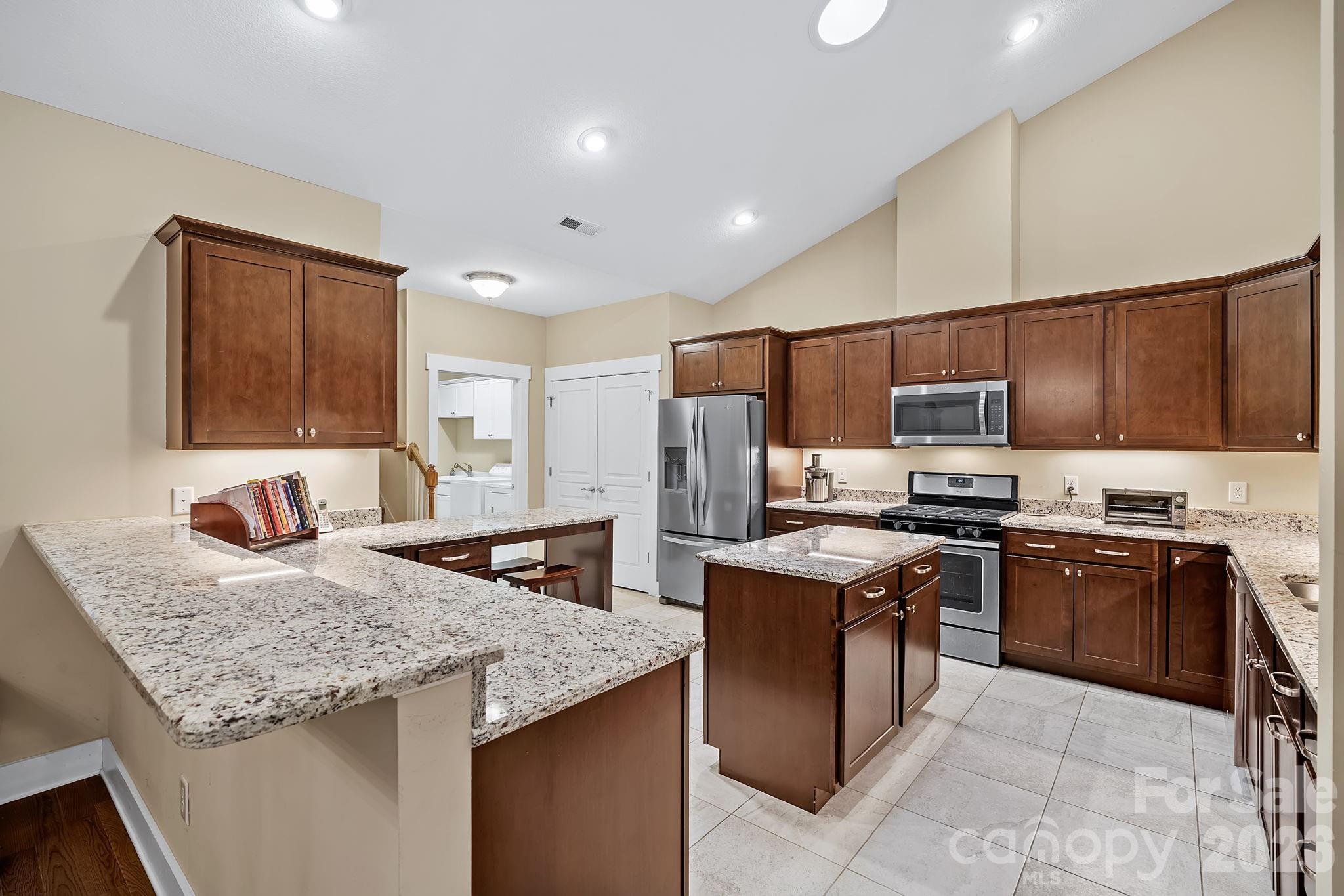 9 Brookstone Place Candler, NC 28715 - Photo 8 of 36 a kitchen with stainless steel appliances granite countertop a stove top oven a sink dishwasher and a refrigerator