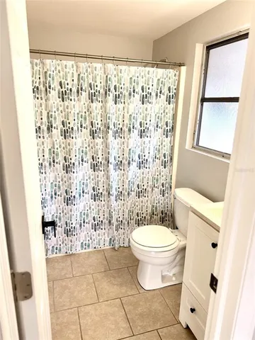 a bathroom with a toilet and a shower curtain