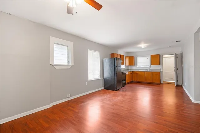 a view of an empty room with window and wooden floor