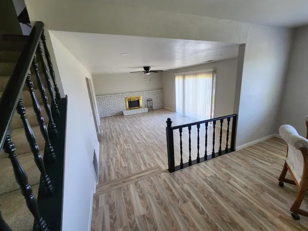 a view of a hallway with wooden floor and staircase