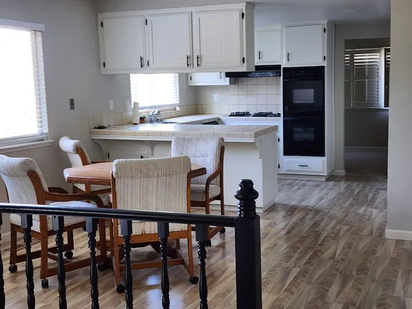 a kitchen with a table chairs refrigerator and cabinets