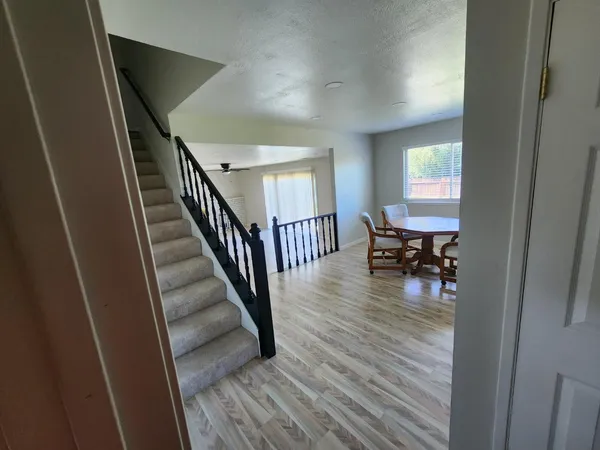 a view of a hallway to a livingroom and dining room with wooden floor