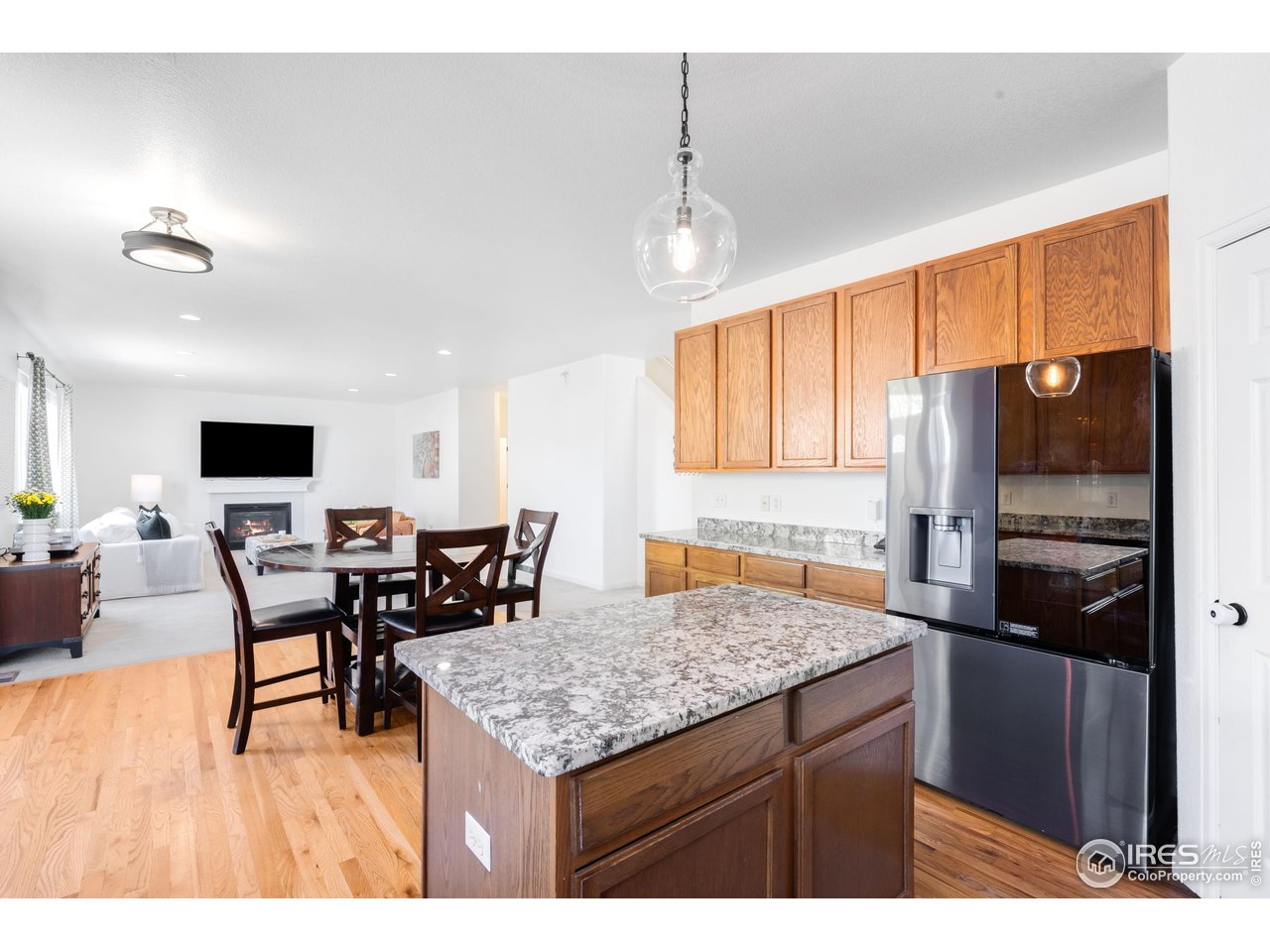 5861 Mountain Shadows Boulevard Firestone, CO 80504 - Photo 16 of 39 a kitchen with stainless steel appliances granite countertop sink refrigerator dining table and chairs