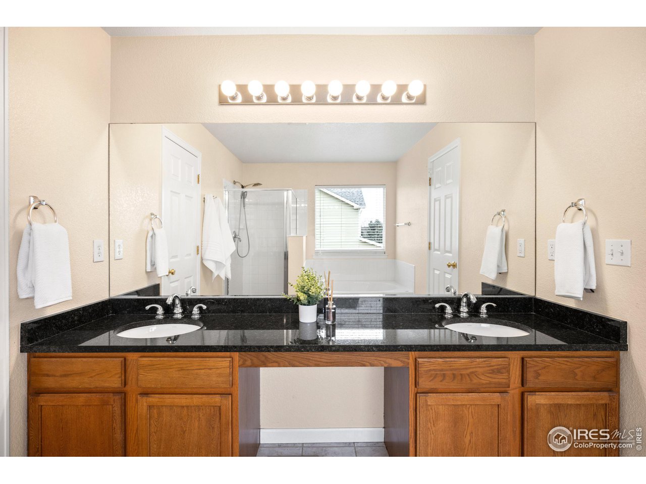 5861 Mountain Shadows Boulevard Firestone, CO 80504 - Photo 23 of 39 a bathroom with a granite countertop sink and a large mirror