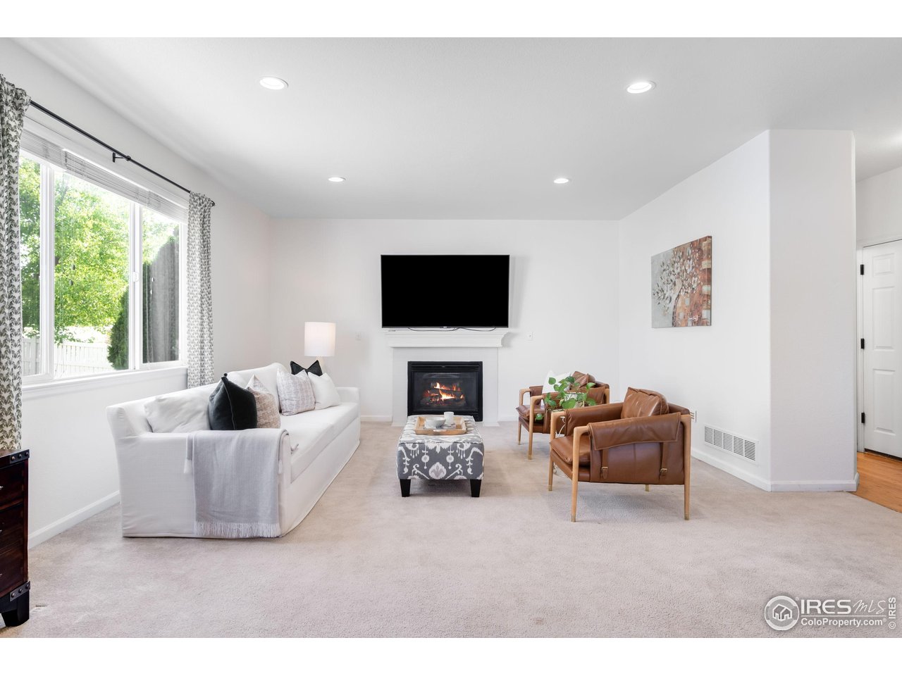 5861 Mountain Shadows Boulevard Firestone, CO 80504 - Photo 9 of 39 a living room with furniture a fireplace and a flat screen tv