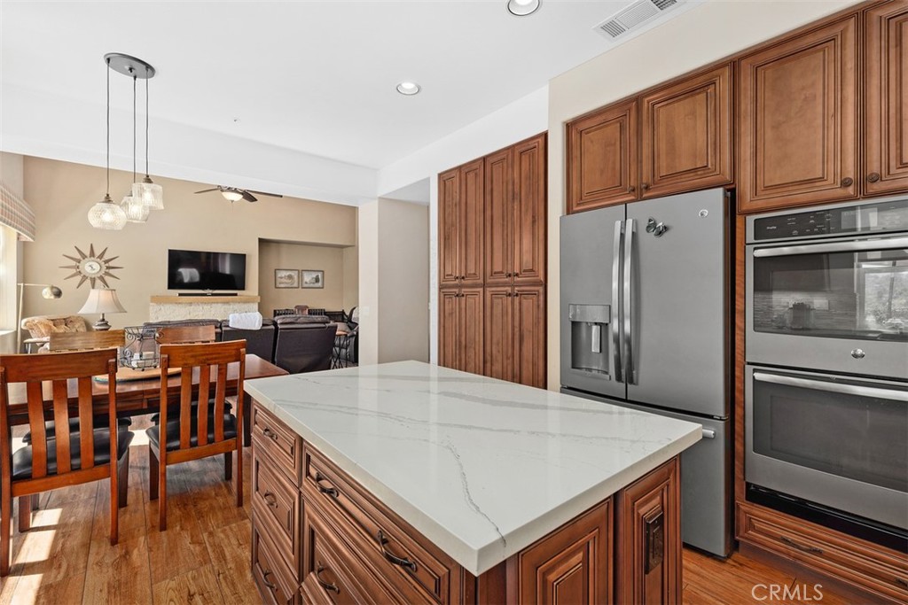 1957 Cresthaven Drive Vista, CA 92084 - Photo 12 of 47 a kitchen with stainless steel appliances granite countertop a refrigerator a stove a sink a dining table and chairs with wooden floor