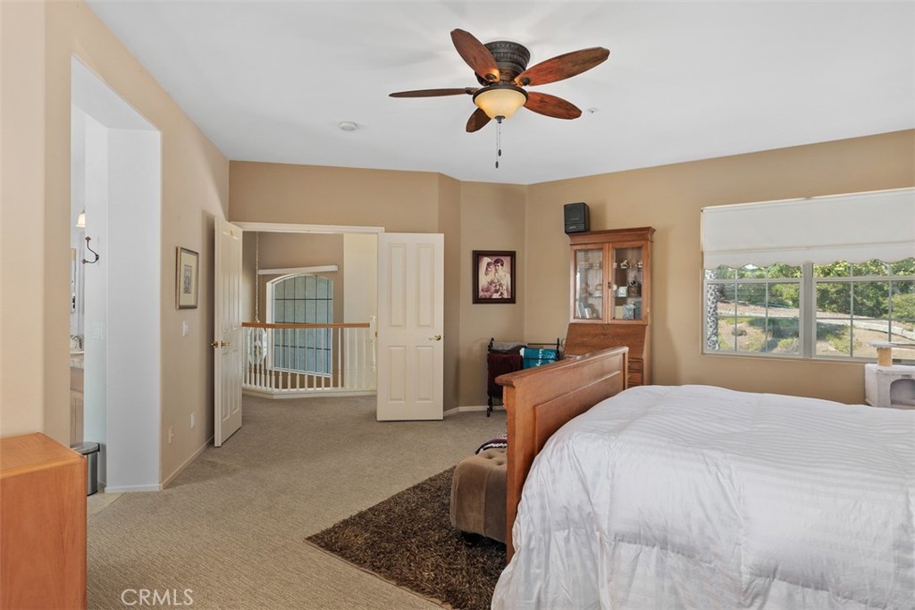 1957 Cresthaven Drive Vista, CA 92084 - Photo 19 of 47 a spacious bedroom with a large bed a chandelier and next to a window