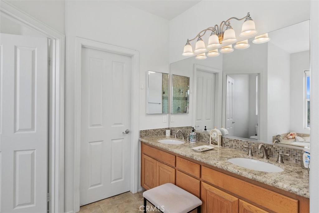1957 Cresthaven Drive Vista, CA 92084 - Photo 20 of 47 a bathroom with a granite countertop sink a toilet and a mirror