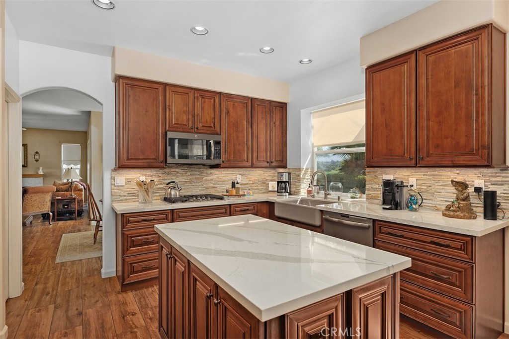 1957 Cresthaven Drive Vista, CA 92084 - Photo 10 of 47 a kitchen with a stove a sink a microwave and wooden cabinets