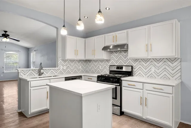 a kitchen with white cabinets and appliances