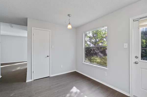 a view of an empty room with window and hallway