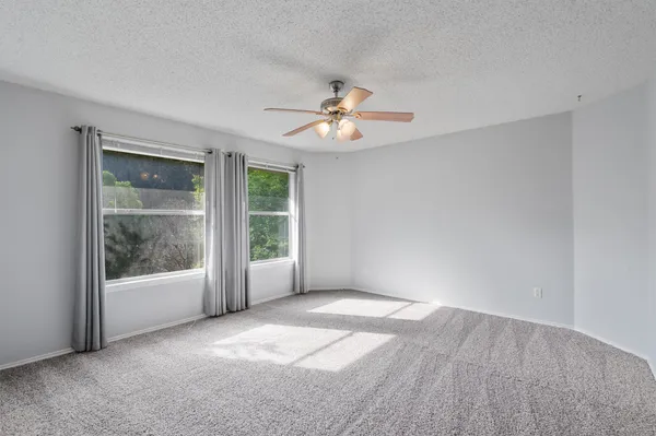 a view of a room with a ceiling fan and a window