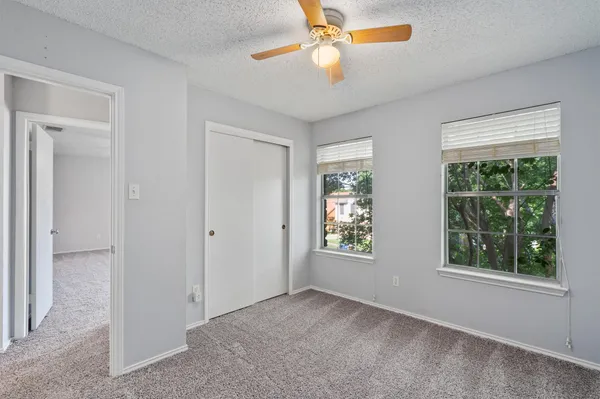 a view of empty room with window and ceiling fan