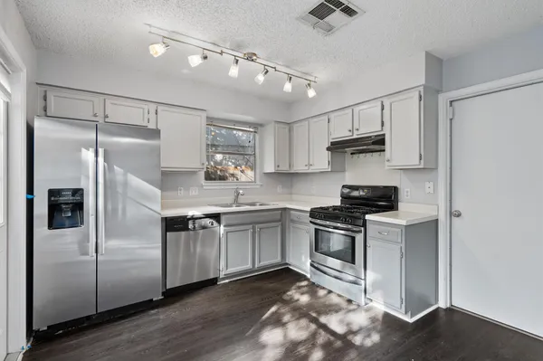 a kitchen with stainless steel appliances granite countertop a refrigerator a stove a sink and a refrigerator