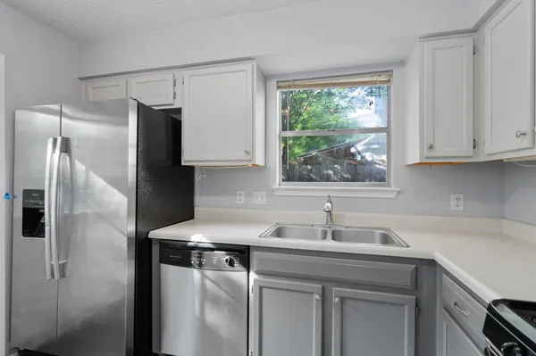 a kitchen with stainless steel appliances granite countertop a sink a refrigerator and a stove