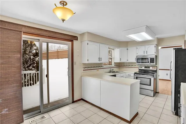 a kitchen with stainless steel appliances granite countertop a refrigerator sink and stove