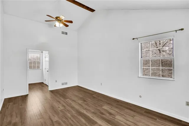 an empty room with a window and wooden floor
