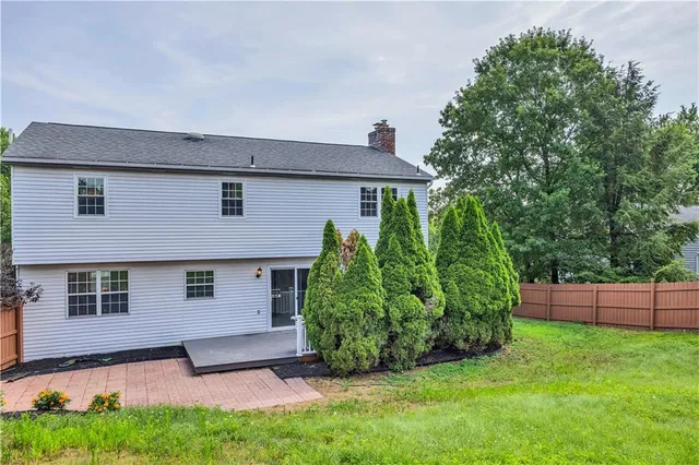 a front view of a house with a yard and trees