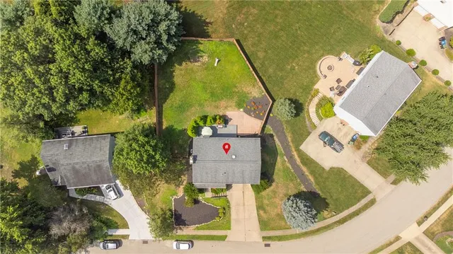 an aerial view of residential houses with outdoor space and a street view