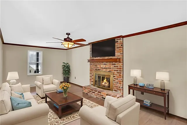 a living room with furniture a fireplace and a flat screen tv