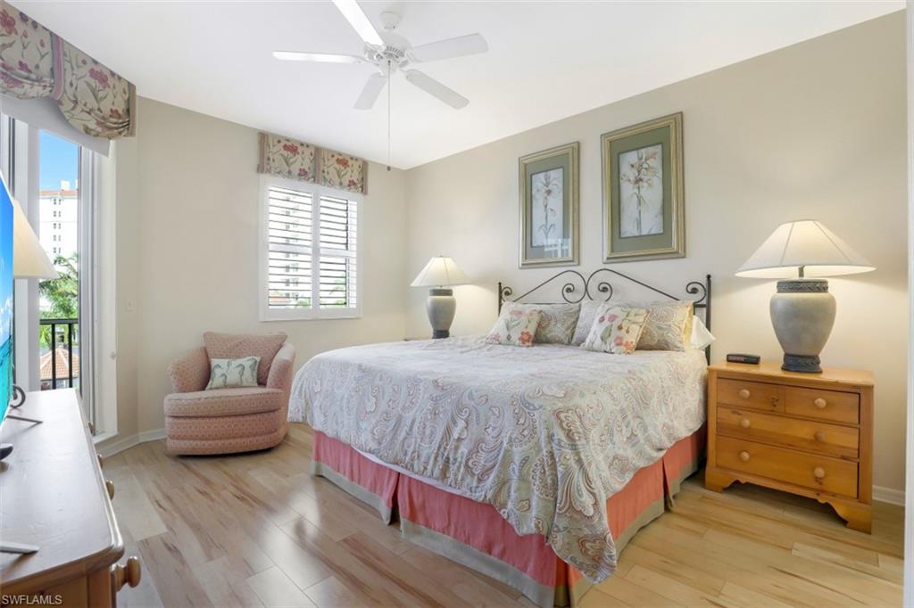 460 Launch Circle, Unit 403 Naples, FL 34108 - Photo 12 of 34 a bedroom with a bed and a couch
