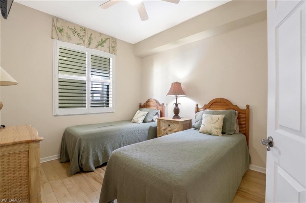 460 Launch Circle, Unit 403 Naples, FL 34108 - Photo 16 of 34 a bedroom with two beds and a window