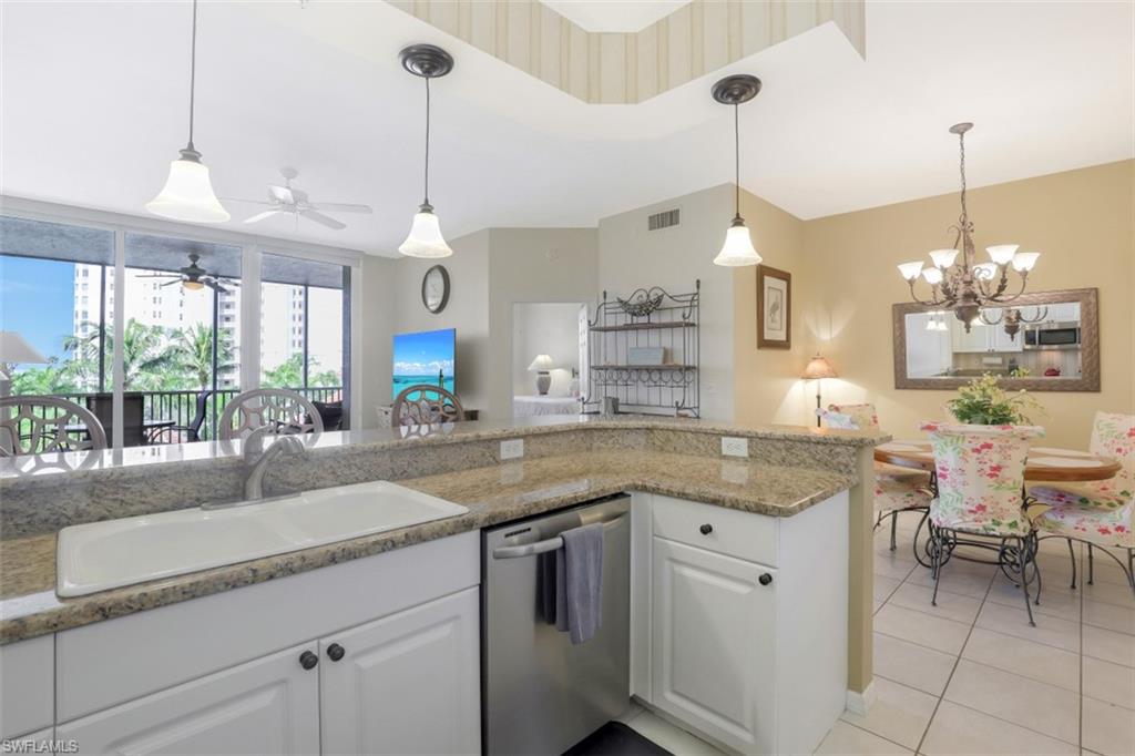 460 Launch Circle, Unit 403 Naples, FL 34108 - Photo 10 of 34 a kitchen with center island and large windows