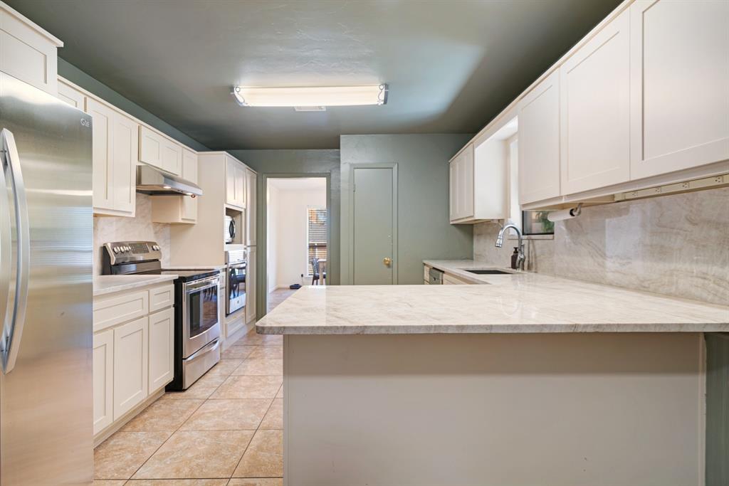 420 39th Street Southeast Paris, TX 75462 - Photo 8 of 25 a kitchen with stainless steel appliances granite countertop a sink stove and refrigerator