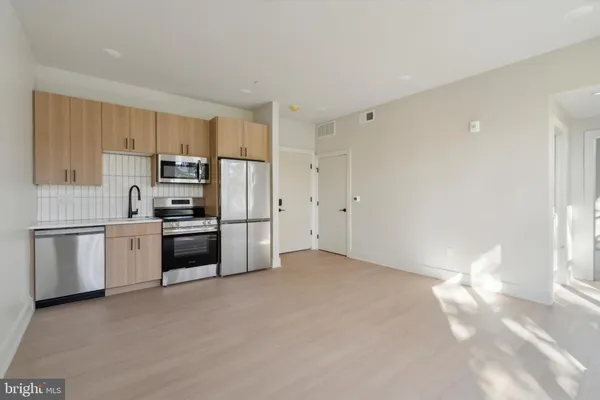 a kitchen with granite countertop white cabinets and stainless steel appliances