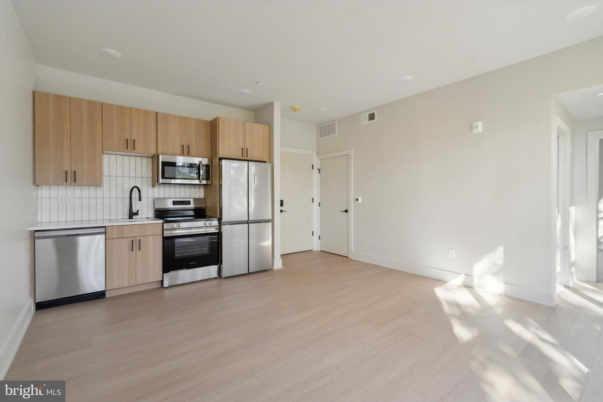 a kitchen with granite countertop white cabinets and stainless steel appliances