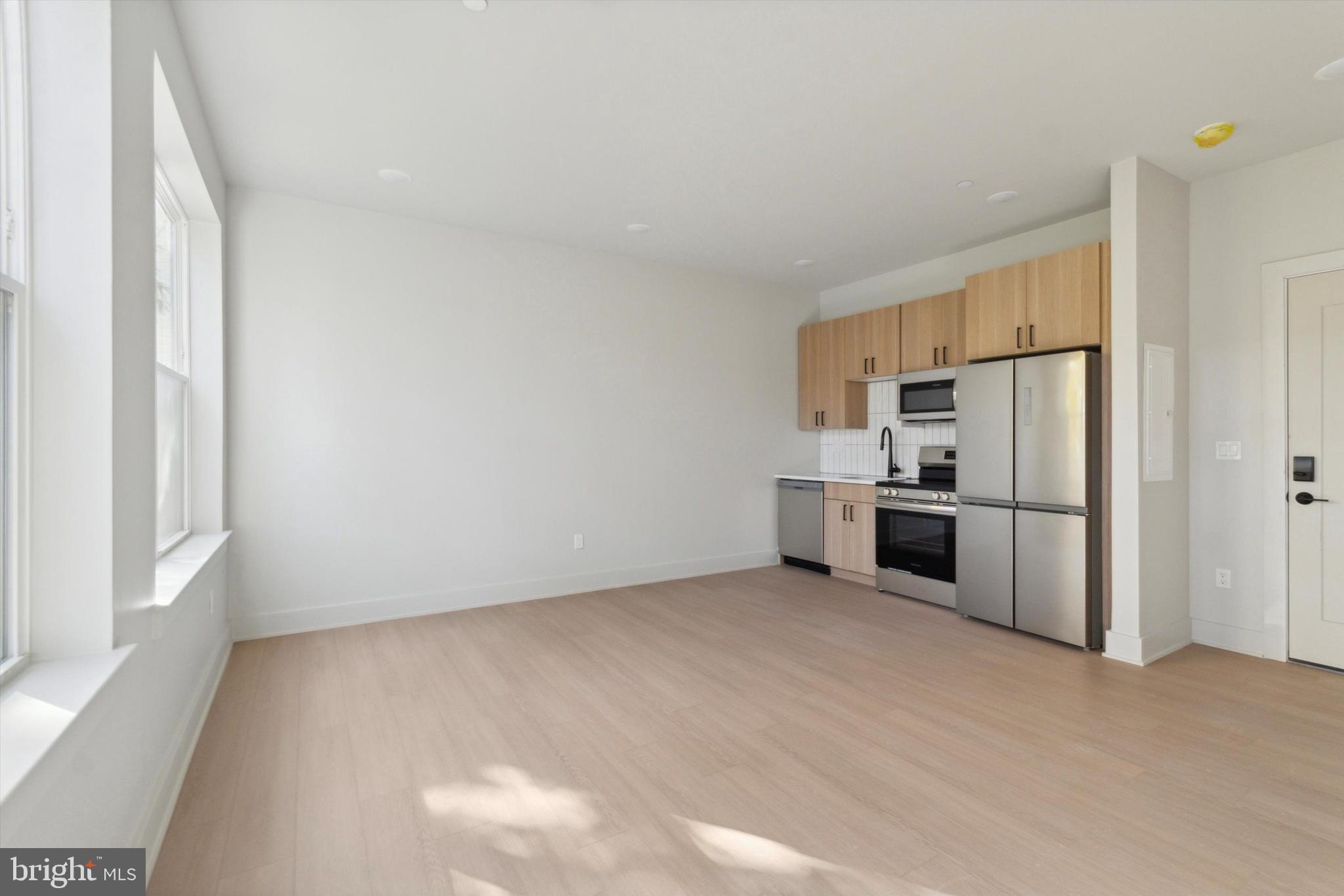 5521 Wayne Avenue, Unit 207 Philadelphia, PA 19144 - Photo 15 of 16 a view of a kitchen with a sink stove refrigerator and windows