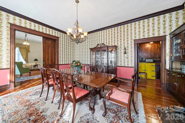 a dining room with furniture a chandelier and wooden floor
