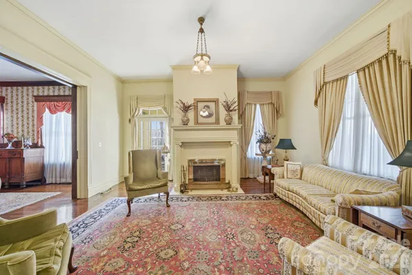 a living room with furniture a fireplace and a chandelier