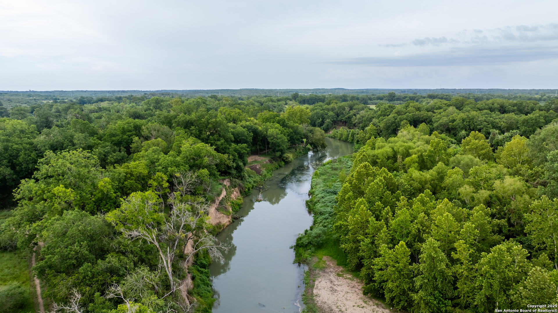 an aerial view of a house with a yard and lake view