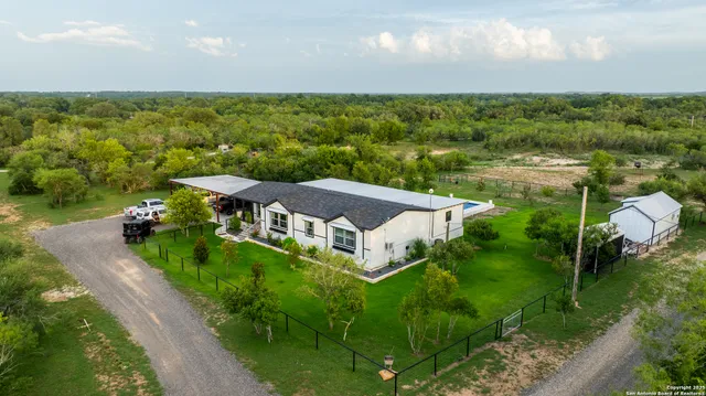 an aerial view of house with yard and mountain view in back