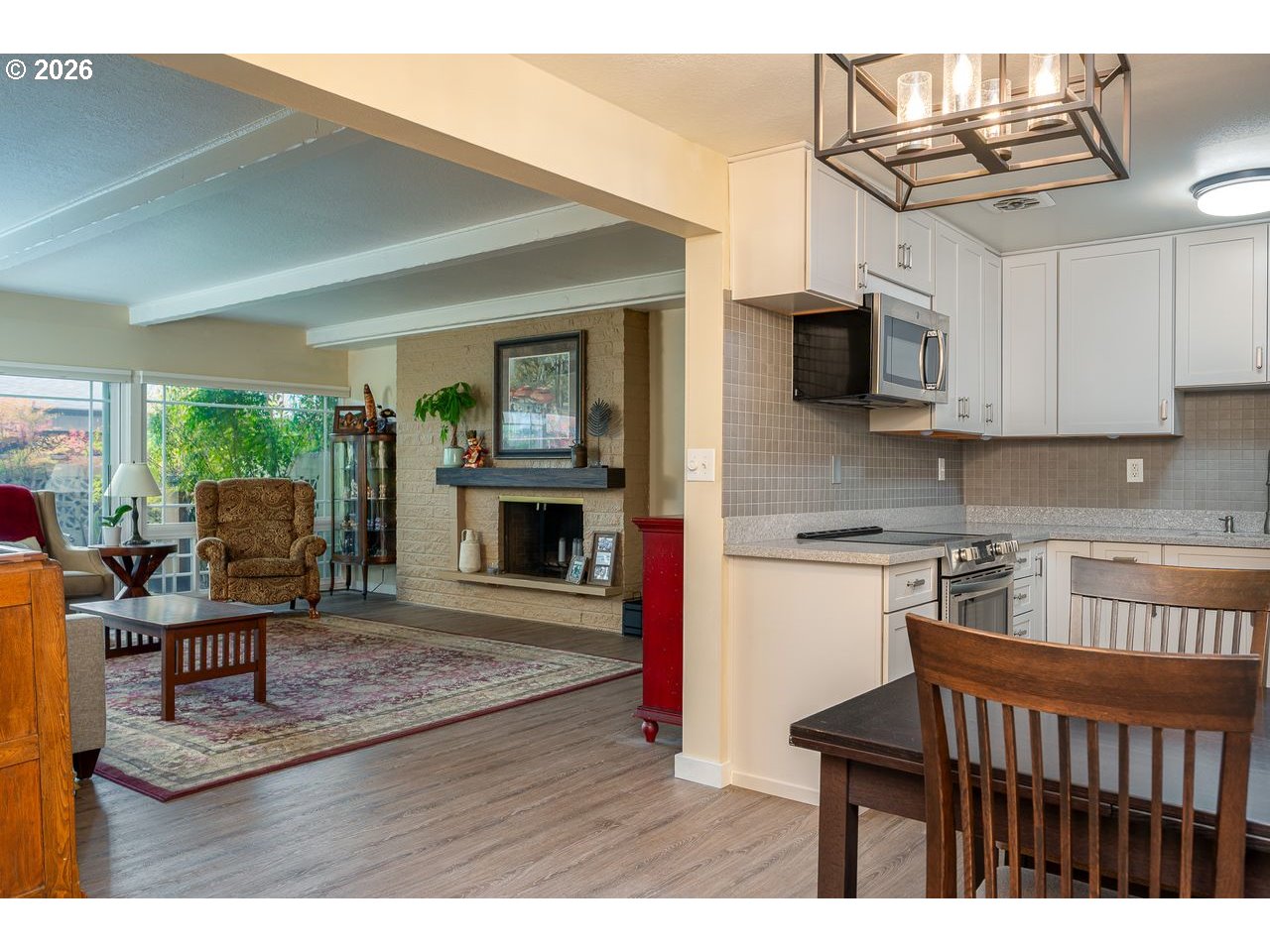 4460 Southwest Scholls Ferry Road, Unit 6A Portland, OR 97225 - Photo 7 of 25 a kitchen with stainless steel appliances granite countertop a stove top oven a sink a dining table and chairs with wooden floor