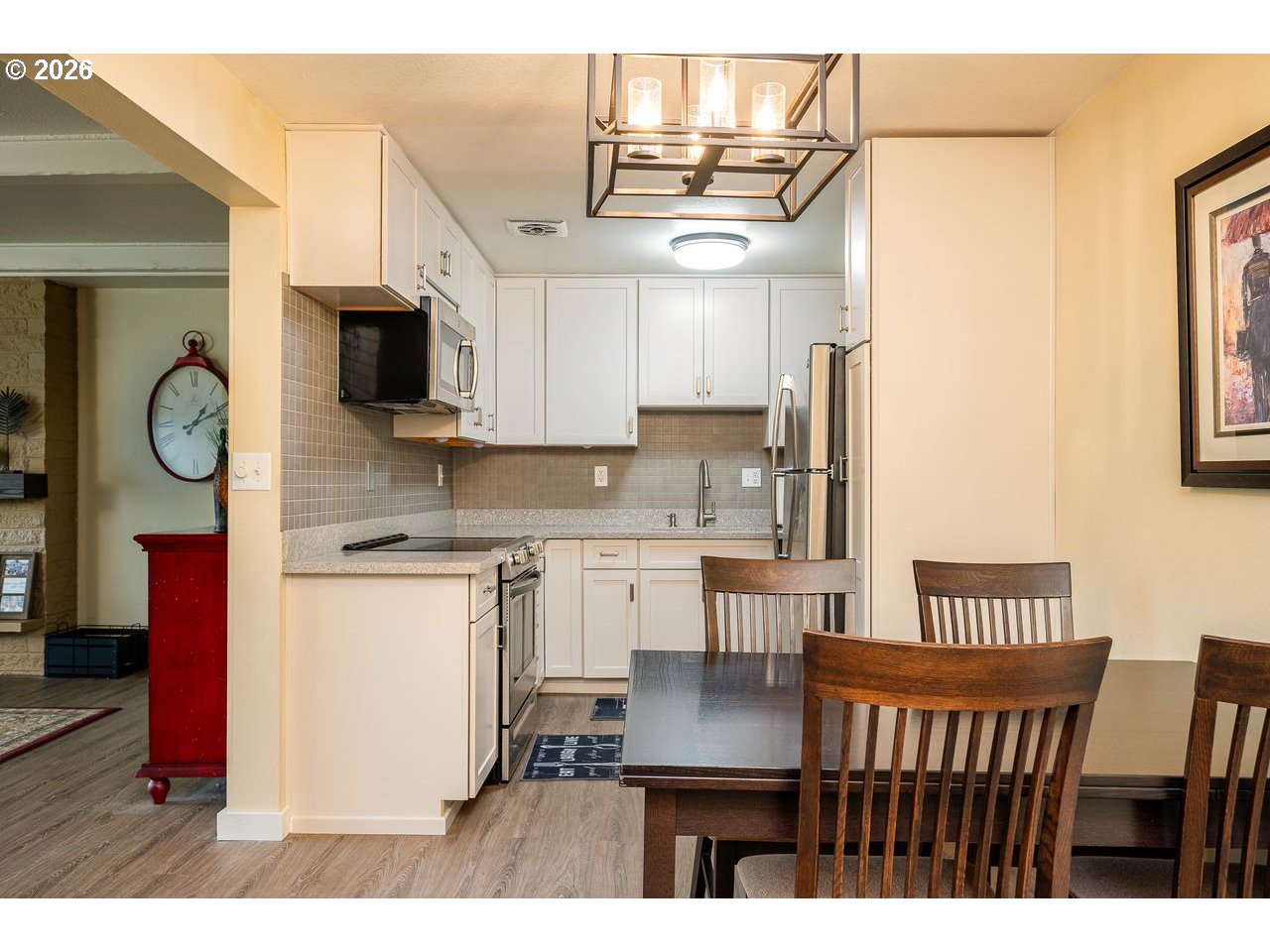 4460 Southwest Scholls Ferry Road, Unit 6A Portland, OR 97225 - Photo 8 of 25 a kitchen with kitchen island granite countertop a sink cabinets a refrigerator a stove a dining table and chairs