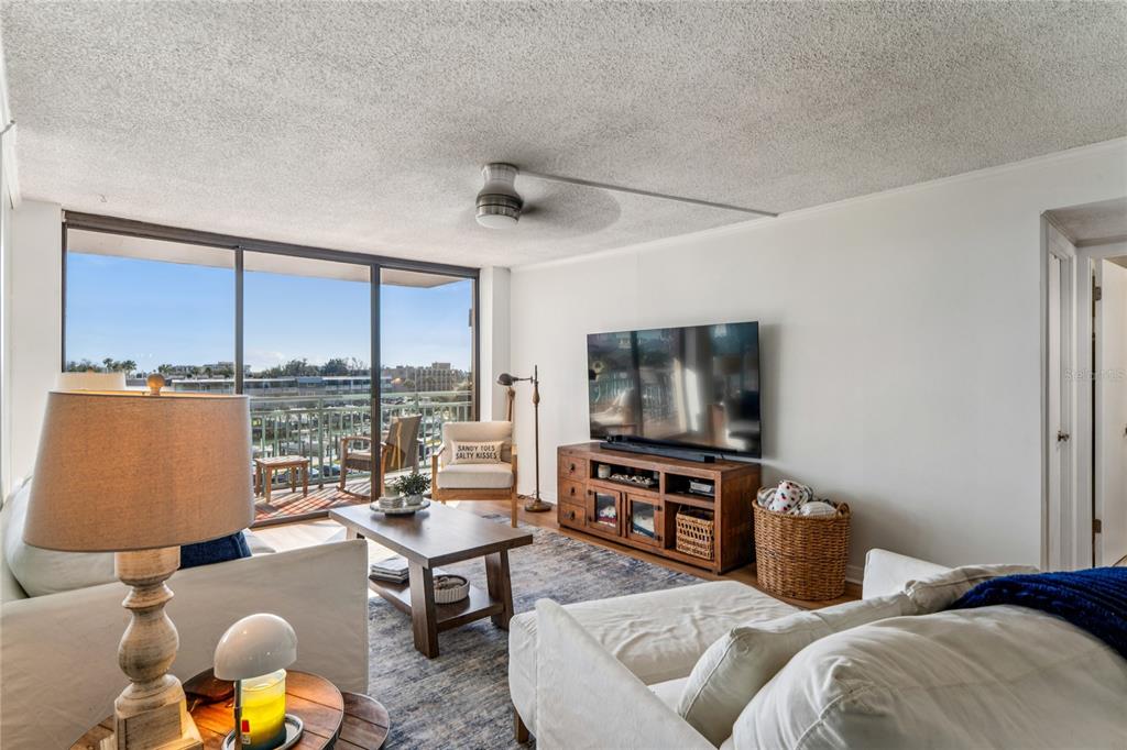 1 Key Capri, Unit 312E Treasure Island, FL 33706 - Photo 11 of 86 a living room with furniture and a flat screen tv