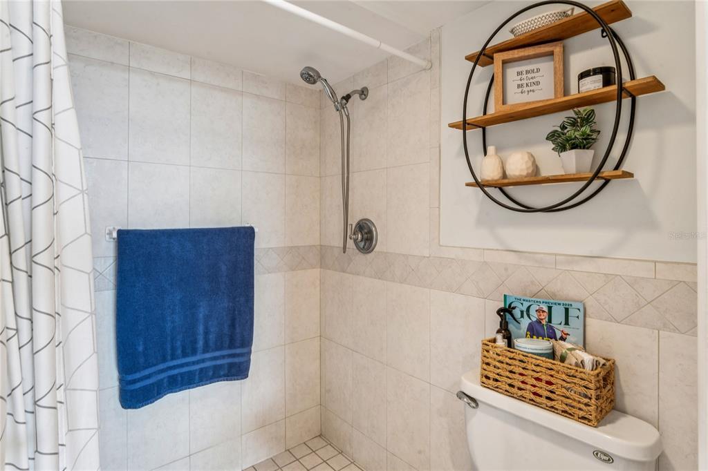 1 Key Capri, Unit 312E Treasure Island, FL 33706 - Photo 29 of 86 a bathroom with a mirror a shower and a sink