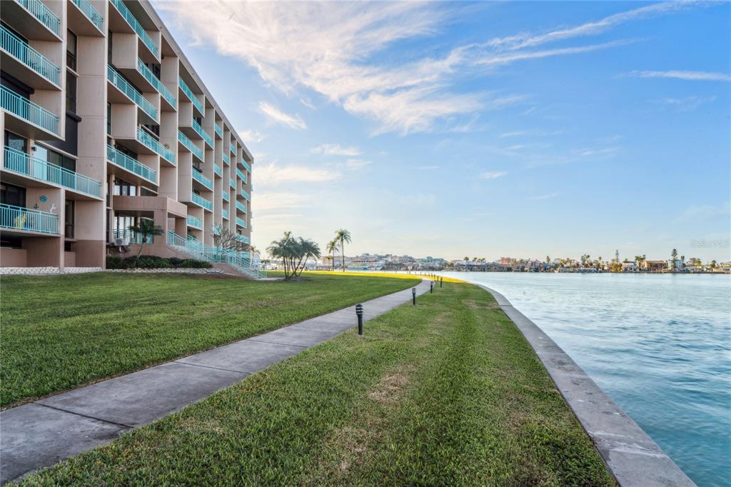 1 Key Capri, Unit 312E Treasure Island, FL 33706 - Photo 56 of 86 a view of a lake with a big yard and large trees