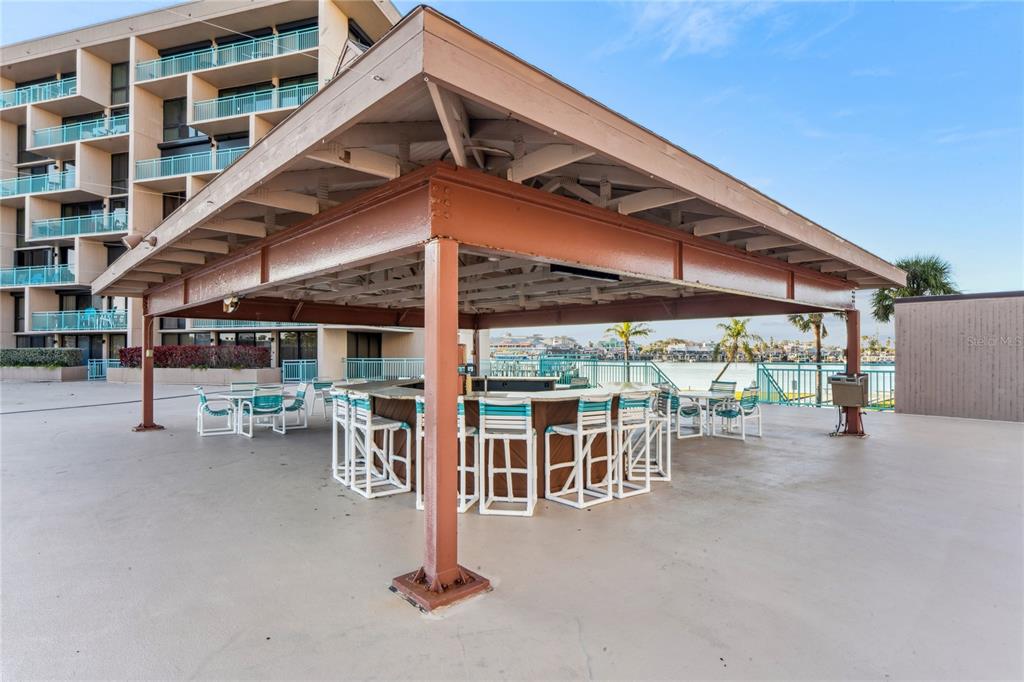 1 Key Capri, Unit 312E Treasure Island, FL 33706 - Photo 62 of 86 a view of a patio with a table and chairs under an umbrella