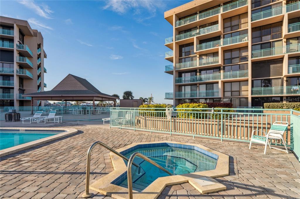 1 Key Capri, Unit 312E Treasure Island, FL 33706 - Photo 64 of 86 a view of a swimming pool with a lounge chairs
