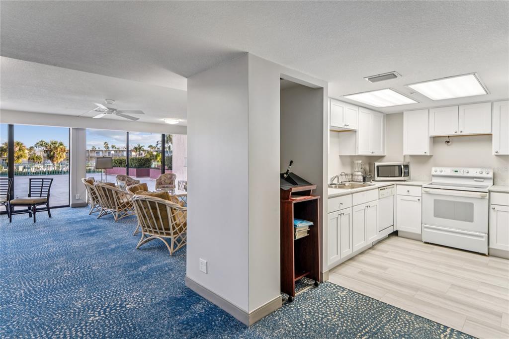 1 Key Capri, Unit 312E Treasure Island, FL 33706 - Photo 74 of 86 a kitchen with a table chairs and a refrigerator