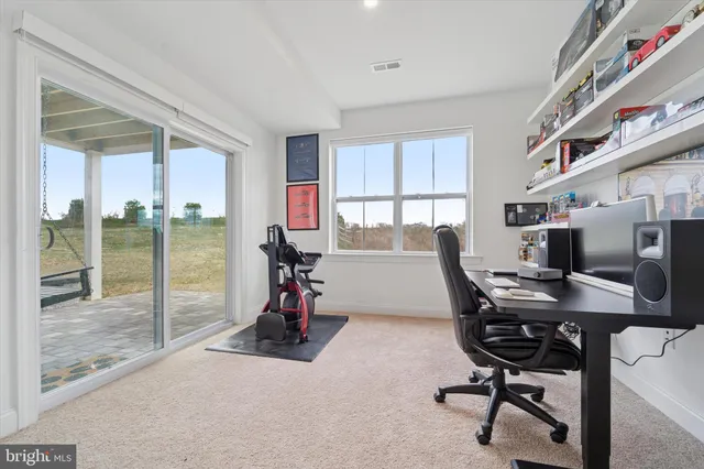a living room with furniture a red couch and gym equipment