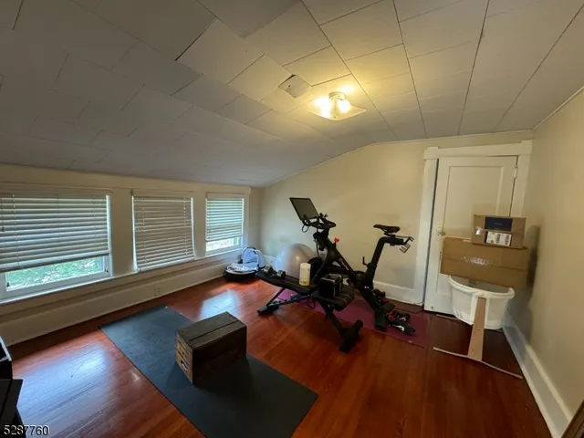 a living room with furniture floor to ceiling window and wooden floor