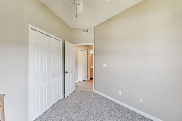an empty room with a window and a ceiling fan