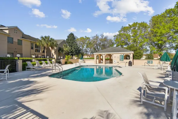 a view of a patio with table and chairs and a large tree