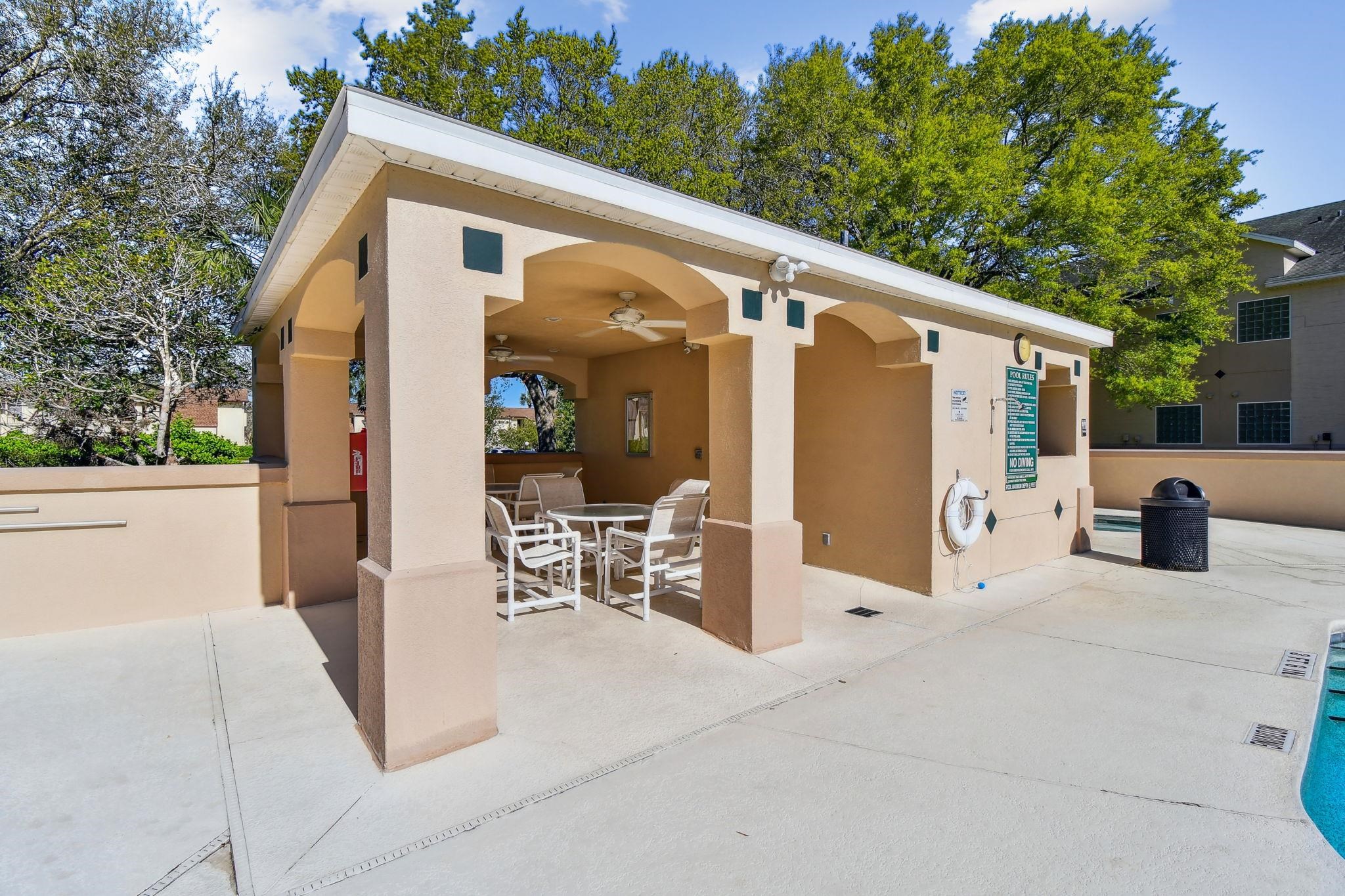 202 Augusta Circle St. Augustine, FL 32086 - Photo 30 of 35 a view of a patio with table and chairs and a large tree