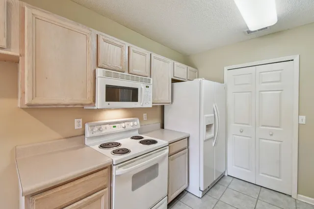 a white stove top oven sitting inside of a kitchen